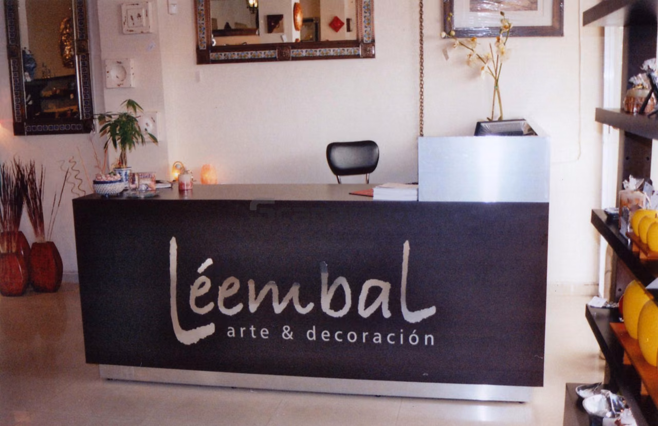 Mostrador de recepción oscuro con el logotipo de Léembal en el frente, en una tienda