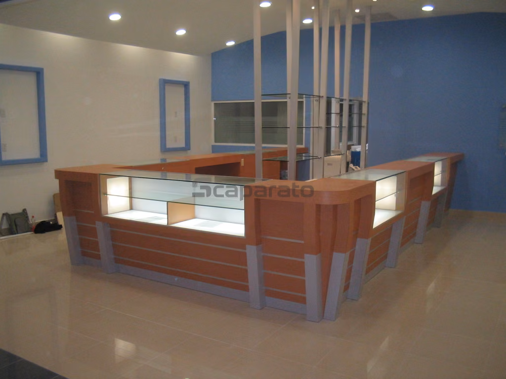 Mostrador de atención de madera clara con vitrina de vidrio al centro y cajones